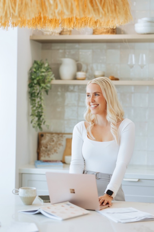 A business owner working at her laptop in a bright, styled space